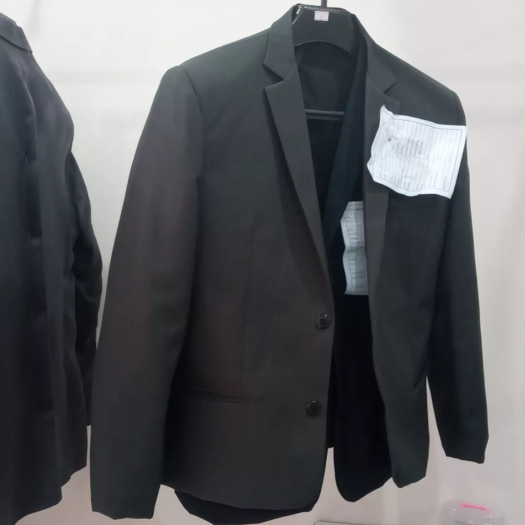 Paletó preto em ajuste de alfaiataria, pendurado no cabide